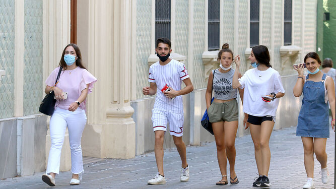Gente con y sin mascarilla camina por una calle de Almería.