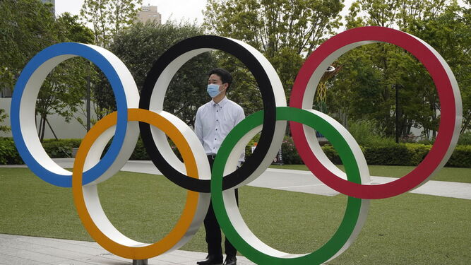 Un residente de Tokio posa con los aros olímpicos.