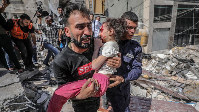 Un padre palestino evacua a su hija, herida durante un ataque israelí en Gaza.