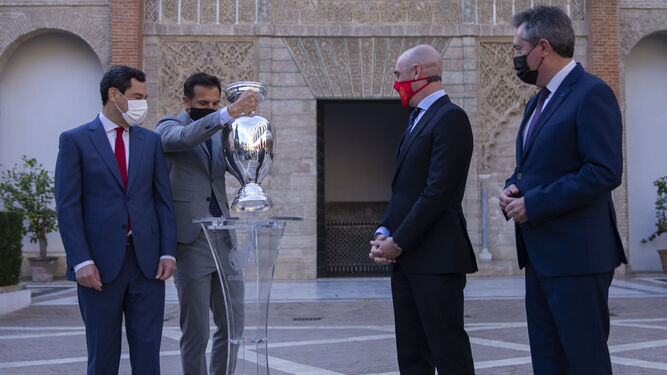 El ex futbolista Carlos Marchena levanta el trofeo en presencia de Juanma Moreno, Rubiales y Espadas.