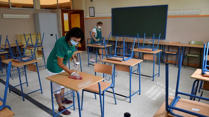Dos trabajadoras limpian el aula de un instituto.