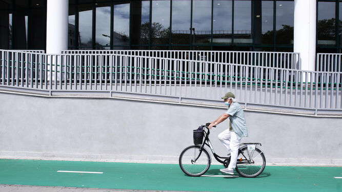 Un ciclista por la estación de autobuses plaza de armas, con una bici de alquiler de la estación.