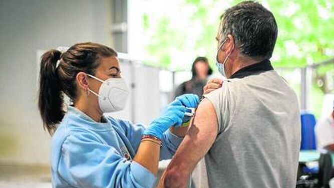 Una enfermera administra una dosis a un hombre en un punto de vacunación de Granada.