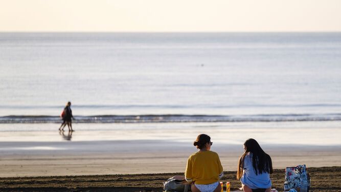 Dos jóvenes charlan en la playa de Maspalomas, en el sur de Gran Canaria.