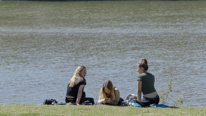 Varias chicas toman el sol junto al río.