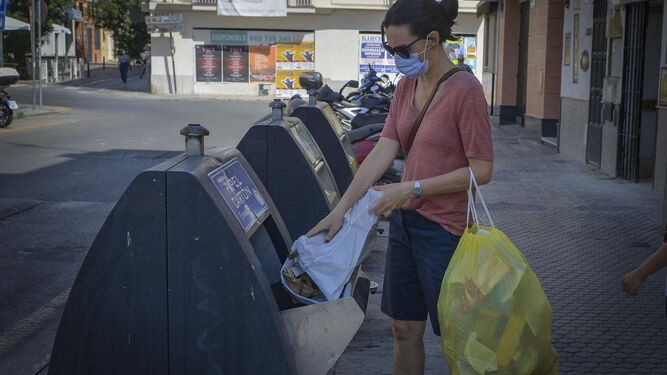 Una ciudadana deposita la basura en un contenedor de recogida selectiva.