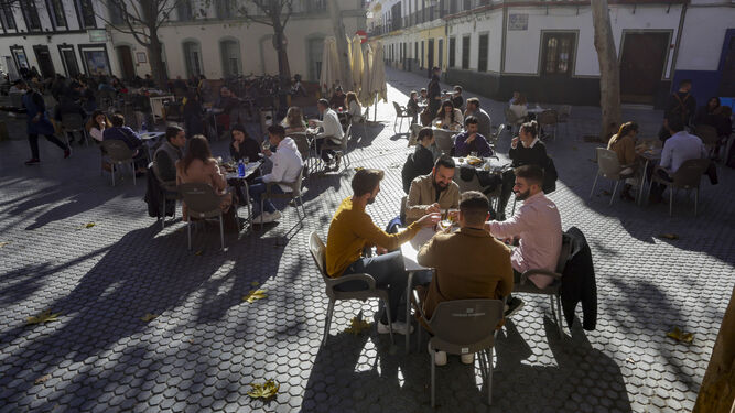 Varias personas coinciden en la terraza de un bar del centro de Sevilla.