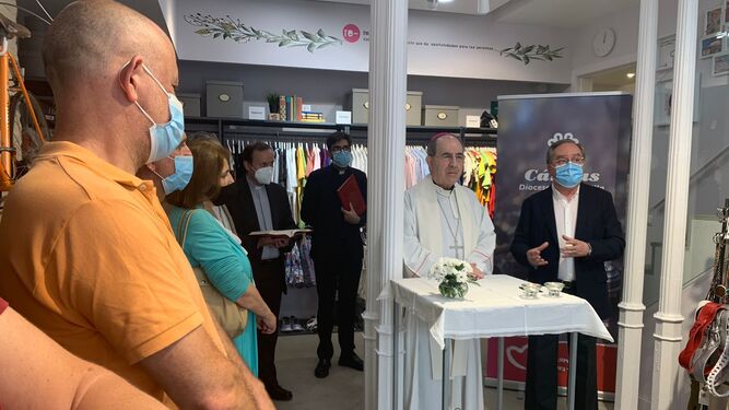 Monseñor Asenjo bendice la tienda de reciclaje de ropa de Cáritas, junto a Mariano Pérez de Ayala.