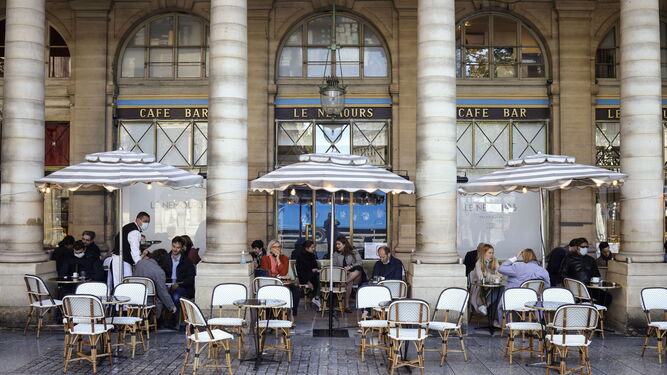 Parisinos tomando café en las inmediaciones del Louvre.