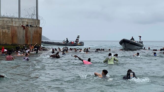 Un grupo de personas tratan de llegar a nado  hacia uno de los espigones de Ceuta en la avalancha migratoria del pasado mayo.