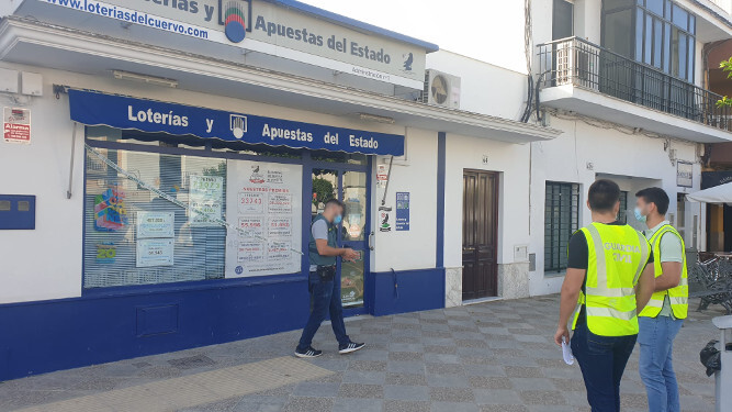 Varios agentes precintan una administración de loterías en El Cuervo.