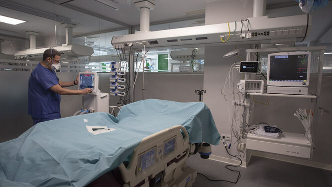 Un sanitario prepara el monitor de una de las habitaciones de UCI del hospital previo a su inauguación.