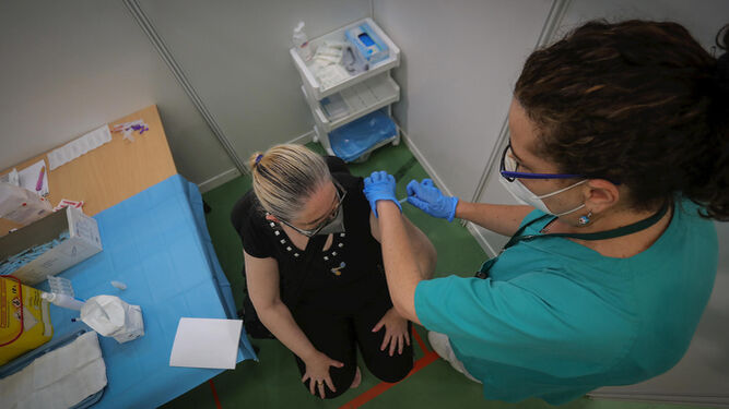 Una mujer se vacuna en un centro.