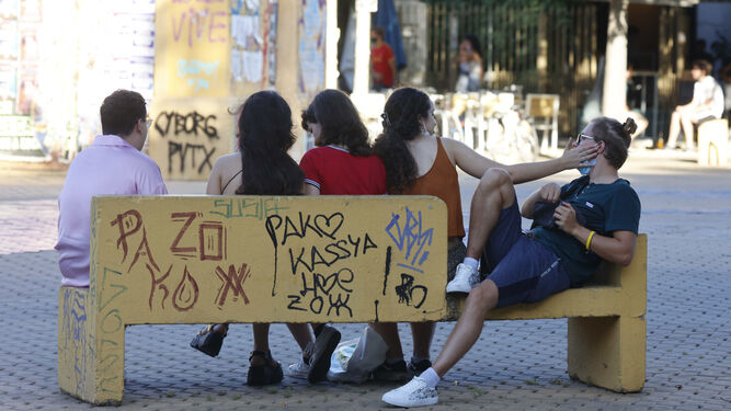 Un grupo de jóvenes comparten un banco en la Alameda de Hércules.
