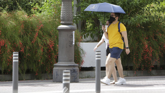 Un turista se protege del sol con un paraguas.