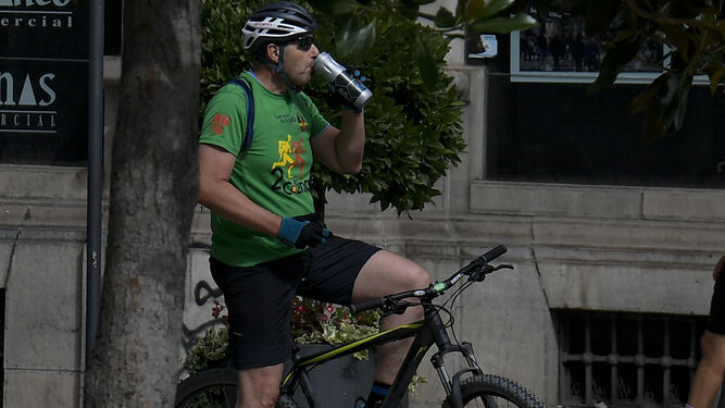 Un ciclista se refresca en una calle del centro de Granada
