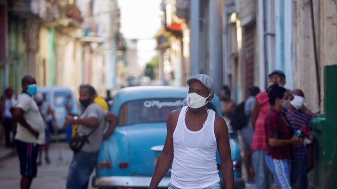 Un hombre camina con cartones de huevos por las calles de La Habana