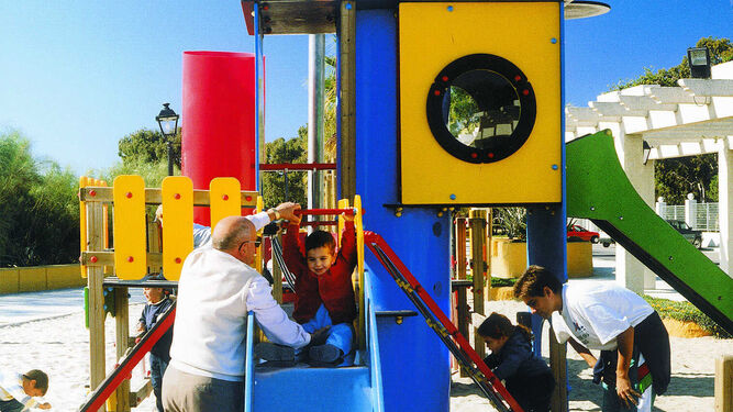 Hijos, padres y abuelos juegan en un parque infantil