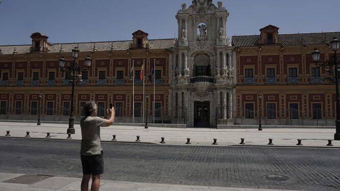 Un viandante fotografía la monumental fachada barroca del Palacio de San Telmo, actual sede del Gobierno andaluz.