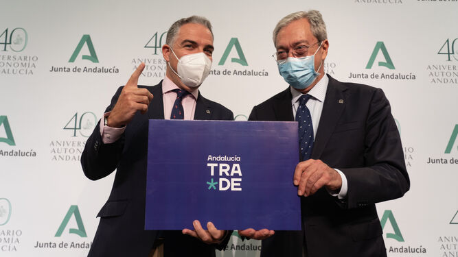 Elías Bendodo y Rogelio Velasco, en San Telmo con un cartel donde se ve el logotipo de Trade