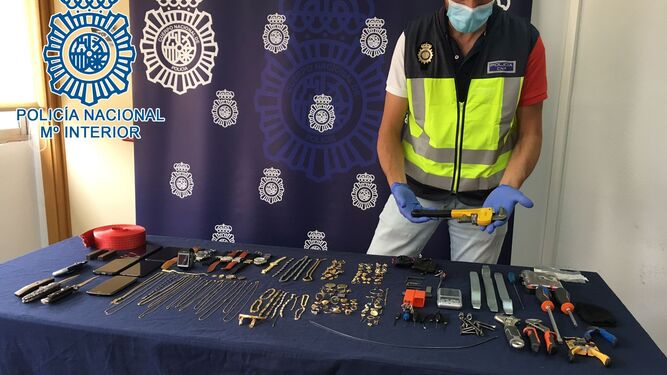 Un policía nacional muestra las joyas y objetos recuperados a la mafia georgiana.