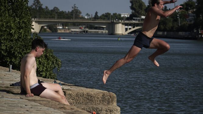 Unos jóvenes se bañan en el Río Guadalquivir para combatir el calor
