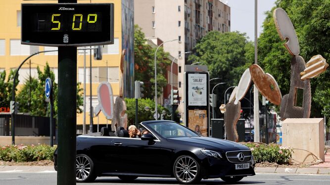 Un coche pasa junto a un termómetro que marca 50 grados en Murcia