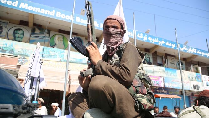 Un talibán muestra su fusil de asalto subido en un 4X4