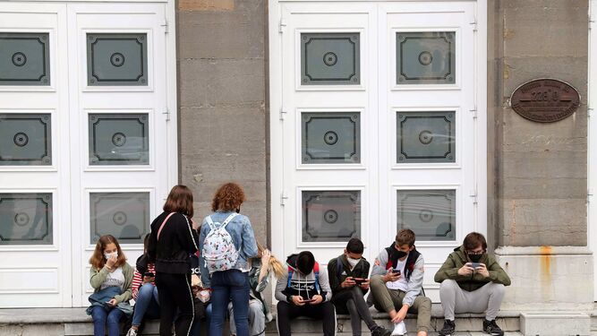Un grupo de jóvenes con mascarilla  a la entrada del Teatro Campoamor en Oviedo.