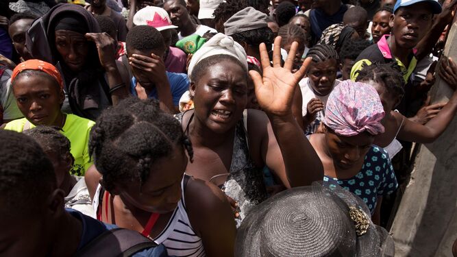 Un grupo de haitianos espera para recibir comida tras los innumerables destrozos ocasionados por el terremoto.