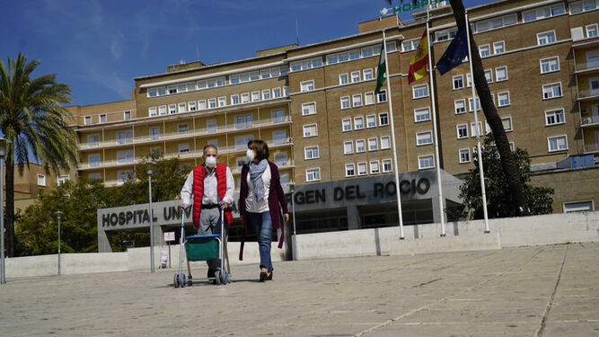 Dos personas saliendo del Hospital Universitario Virgen del Rocío