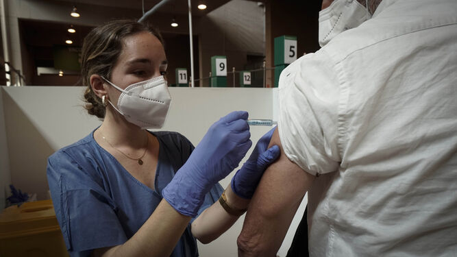Una sanitaria inyecta una vacuna en el Estadio de la Cartuja de Sevilla.