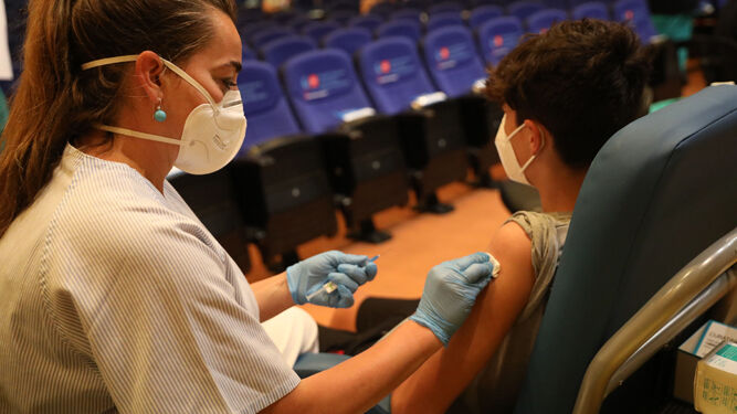 Una sanitaria suministra a un menor la vacuna contra la covid-19.