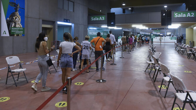 Adolescentes hacen cola en el Estadio de la Cartuja para recibir la vacuna contra el Covid.