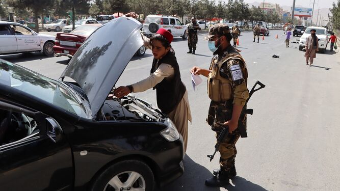Fuerzas talibanes registran un vehículo en una carretera de Kabul.