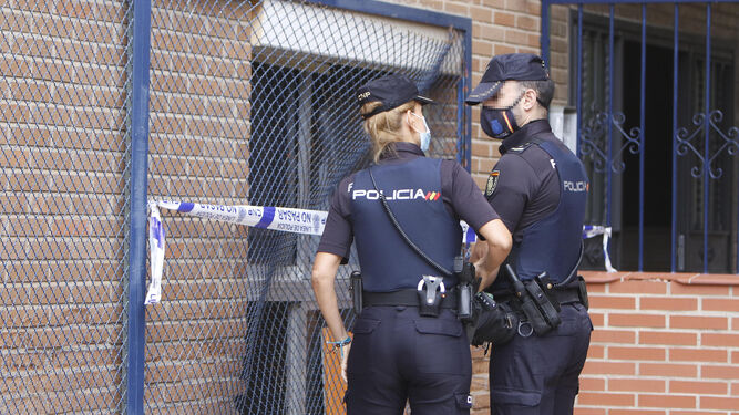 Dos agentes de la Policía Nacional, en la puerta de una vivienda en la que se produjo un homicidio.