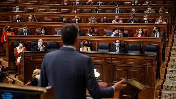 El presidente del Gobierno, Pedro Sánchez (de espaldas), ante la bancada popular en el Congreso este miércoles..