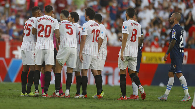 Los futbolistas del Sevilla reclaman a González Fuertes por la expulsión de Delaney.