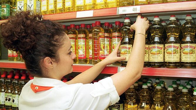 Una empleada de un supermercado, en el lineal dedicado al aceite de oliva.