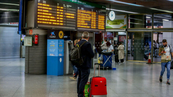 Un viajero mira un panel de cancelaciones en Puerta de Atocha