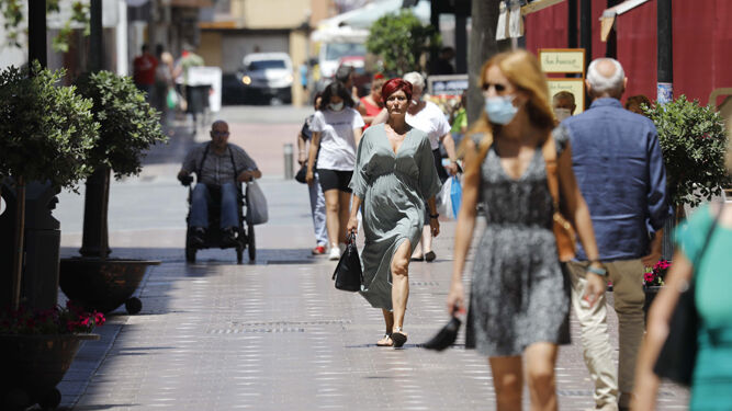 Viandantes con y sin mascarillas por una calle de La Línea.