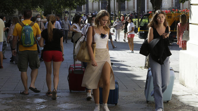 Turistas con maletas por las calles de Sevilla