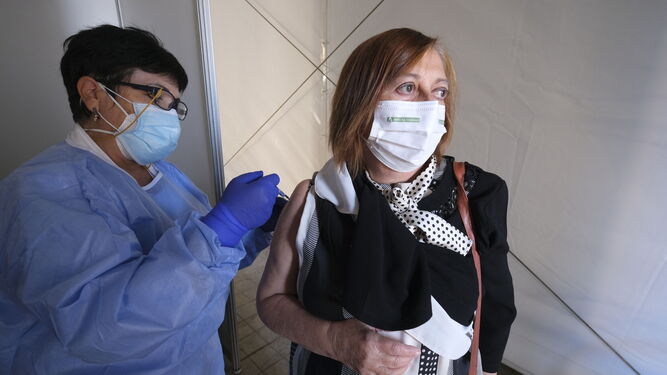 Una sanitaria administra la vacuna de la gripe a una mujer en Almería.