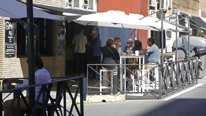 Varias personas en la terraza de un bar.