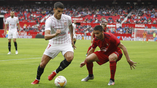 Lamela conduce la pelota con clase delante de Cote en el Sevilla-Osasuna.