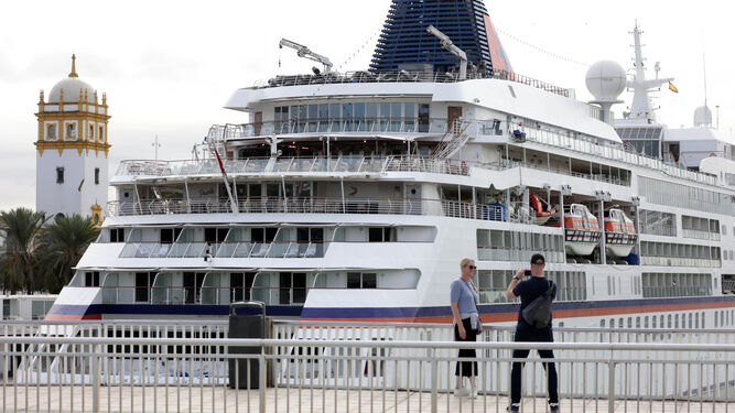 Una pareja se fotografía ante el crucero 'Europa', atracado en el Muelle de las Delicias.