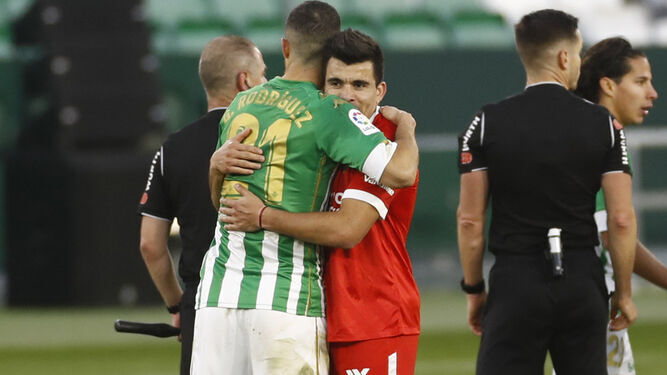 Los argentinos Guido Rodríguez y Acuña se abrazan en el último derbi en el Benito Villamarín.