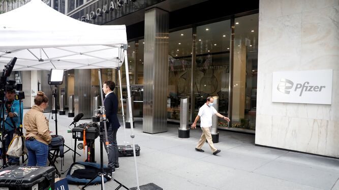Periodistas de TV retransmiten ante la sede de Pfizer en Nueva York.