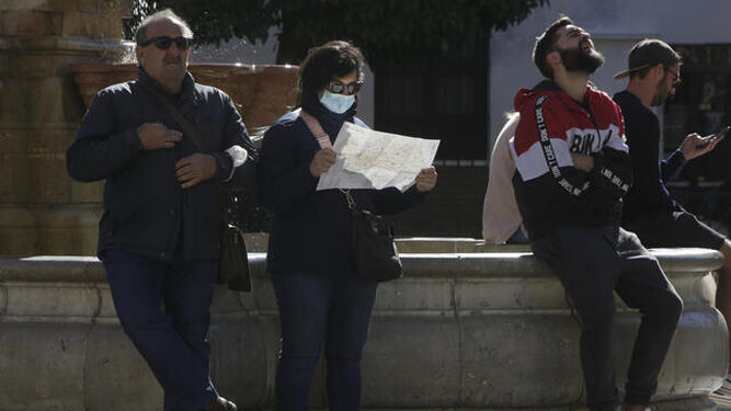 Turistas al sol en el centro de Sevilla.