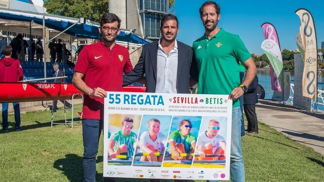 Representantes de los botes del Sevilla y el Betis y posan con el cartel de la prueba.